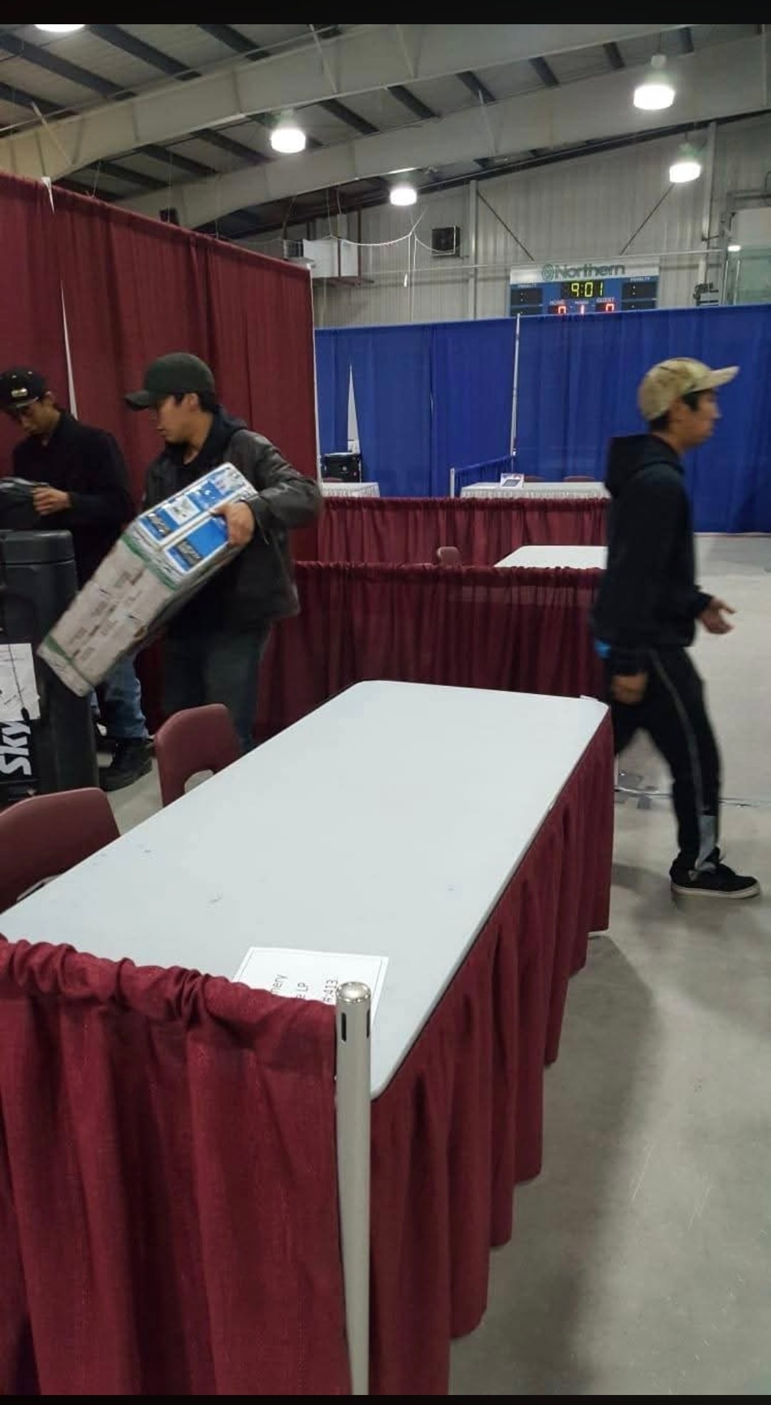 NMS crew moving tables and equipment inside a large event venue