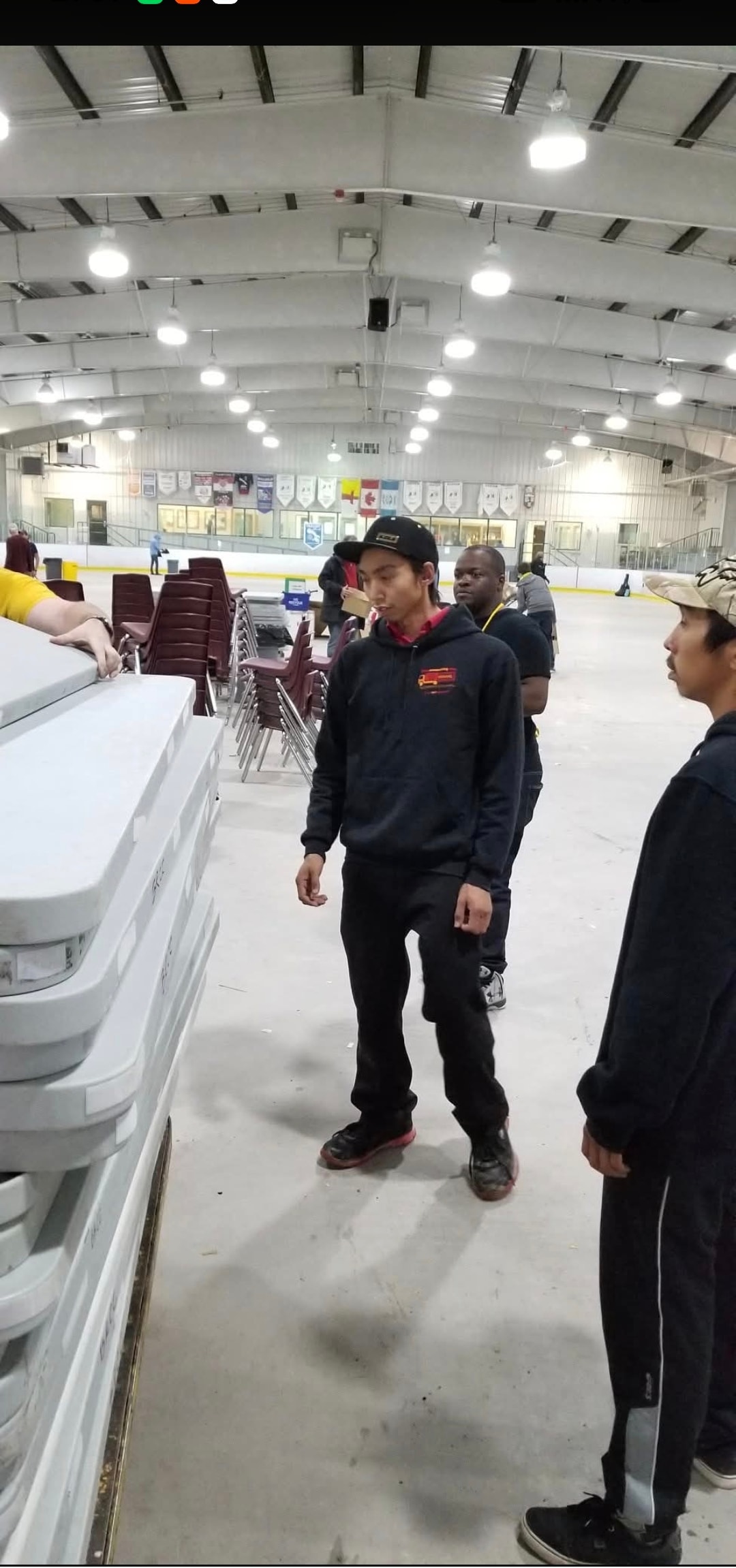 NMS crew handling tables and chairs inside an arena during a commercial move